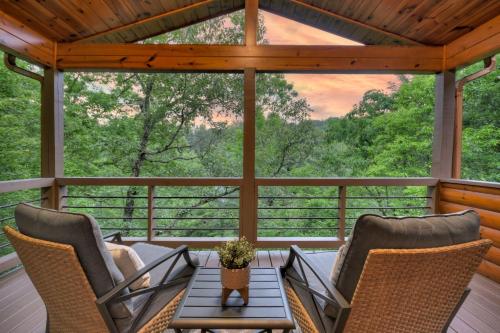 a screened in porch with two chairs and a table at A Little Bit of Heaven Swim in the creek soak in the hot tub and relax in comfort in Copperhill