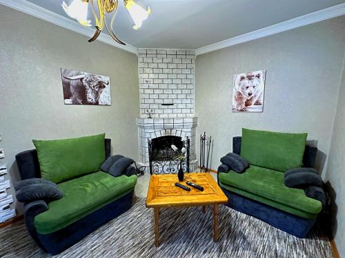 a living room with green couches and a fireplace at Sky Village, Chimgan in Chimgan
