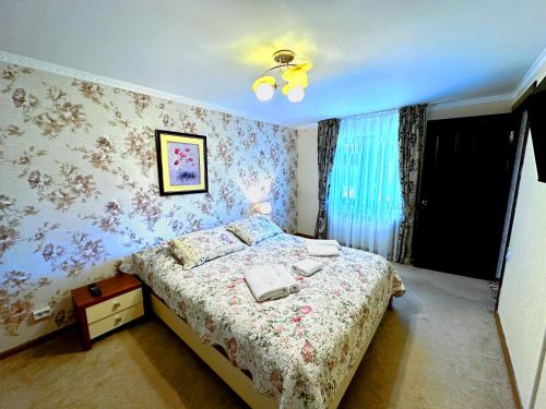 a bedroom with a bed with floral wallpaper at Sky Village, Chimgan in Chimgan