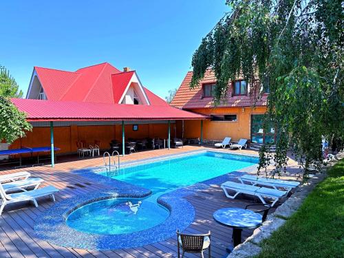 a swimming pool with chairs and a house at Sky Village, Chimgan in Chimgan