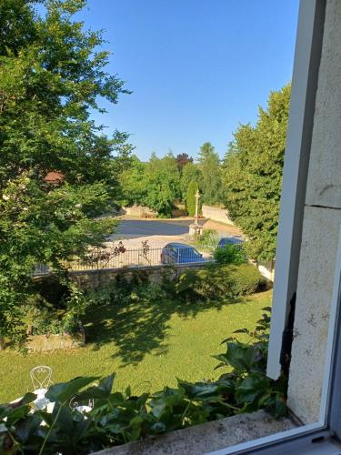 a view of a park from a window at Chic & charme au Presbytère in Saint-Genès-du-Retz