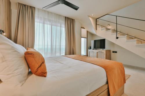 a bedroom with a large bed with a large window at La Brise Luxury Suites in Néa Péramos