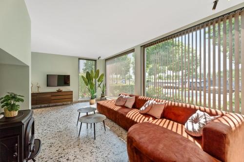 a living room with a couch and a large window at Villa Couleur in Diksmuide