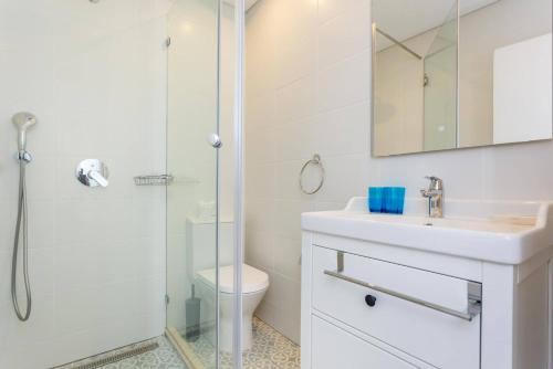 une salle de bain blanche avec lavabo et douche dans l'établissement CoolHouses Algarve Luz, 3 Bed Townhouse w/ beautiful sea view, Luz Bay 76, à Luz