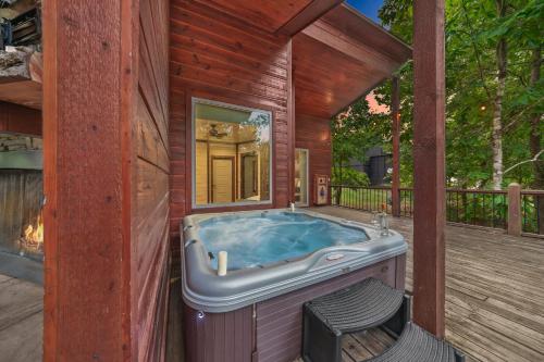 Cabin Retreat with Spa Fire Pit & Games - Sleeps 4 في بروكن بو: حوض استحمام ساخن على سطح المنزل