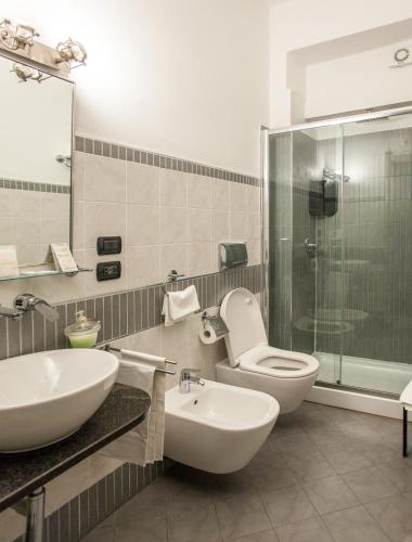 a bathroom with a sink and a toilet and a shower at Hotel Calamosca in Cagliari