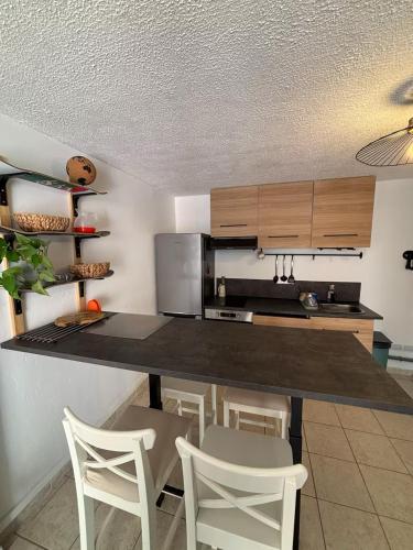 - une cuisine avec un comptoir et des chaises dans la chambre dans l'établissement Appart proche du lac et plages, à Soustons