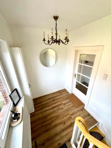 a hallway with a chandelier and wooden floors at Gemütliche Ferienwohnung in Emmerich