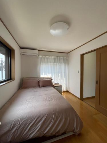 a bedroom with a large bed with a window at 癒し家 in Tokyo