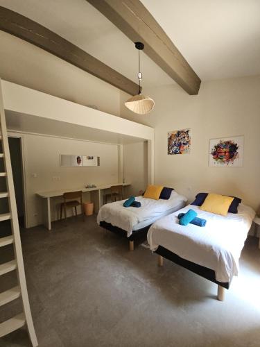 a bedroom with two beds and a desk in it at Chambre individuelle APT in Apt