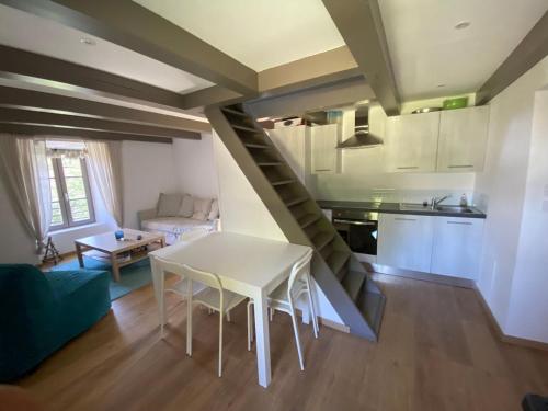 Il comprend une cuisine et un salon avec une table et un escalier. dans l'établissement Pavillon du garde de la Porte d'Embrun, à Aramon