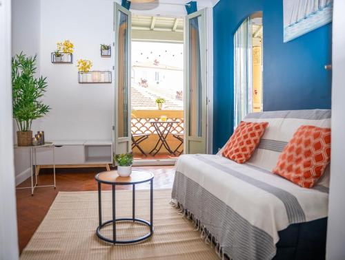 - une chambre avec des murs bleus et un lit avec une table dans l'établissement Rêve Bleu de Nice - Terrace - Beach & Tram 5 min, à Nice