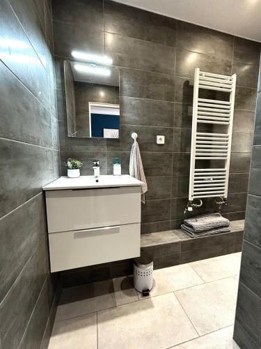 une salle de bain avec un lavabo et un miroir dans l'établissement Rêve Bleu de Nice - Terrace - Beach & Tram 5 min, à Nice