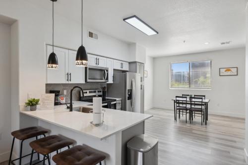 a kitchen and living room with a counter and chairs at CozySuites Glendale - Westgate w pool 15 in Glendale
