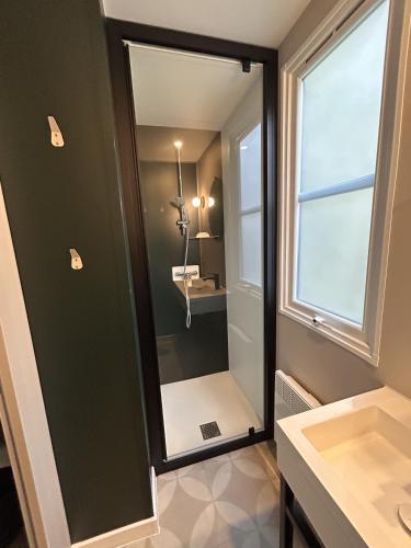 une salle de bain avec un miroir et un lavabo dans l'établissement Le Domaine des Pins, à Saint-Hilaire-de-Riez