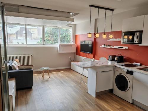 Il comprend une cuisine aux murs rouges et un salon. dans l'établissement R'Apparts Luxury N5, à Grenoble