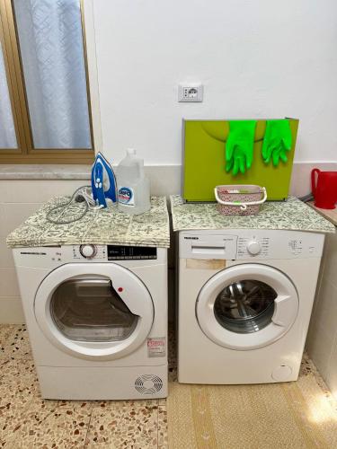 a laundry room with a washing machine and a counter at Piccolo Brasile Home in Capaci