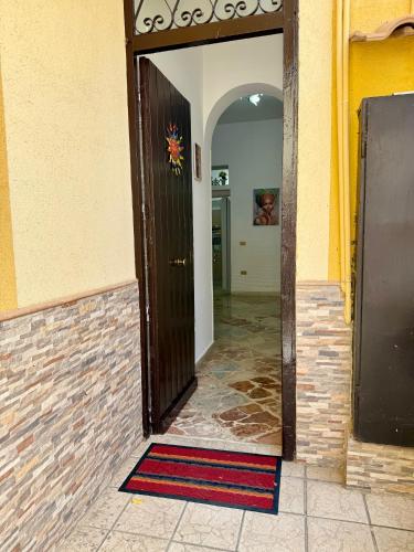 an open door of a building with a rug on the floor at Piccolo Brasile Home in Capaci