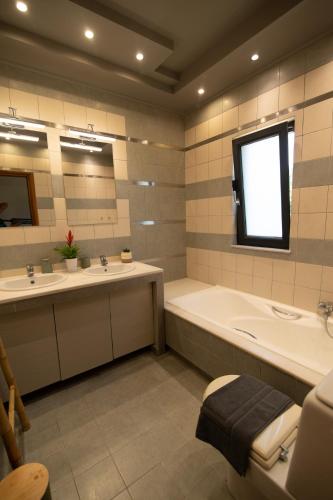 a bathroom with two sinks and a bath tub and a tub at Villa Luce in Kos