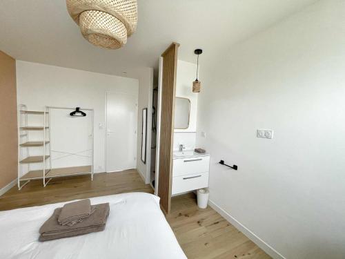 - une chambre blanche avec un lit et un lavabo dans l'établissement Le Wilson, à Vannes