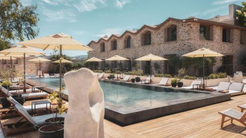 a pool at a hotel with chairs and umbrellas at Ruins Luxury Resort - Adults Only in Yalıkavak