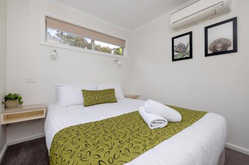 a bedroom with a bed with two towels on it at BIG4 Launceston Holiday Park in Launceston