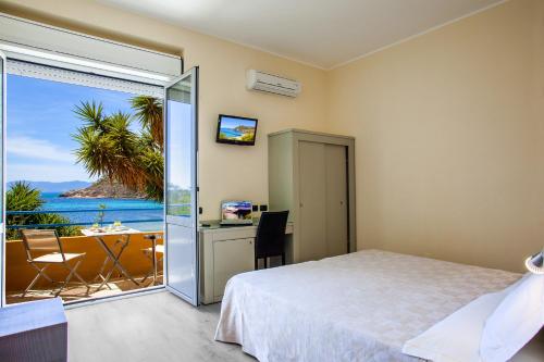 a bedroom with a bed and a view of the ocean at Hotel Calamosca in Cagliari