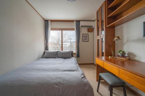 札幌市にあるE-US Naebo HOUSEのベッドと机と窓のある寝室