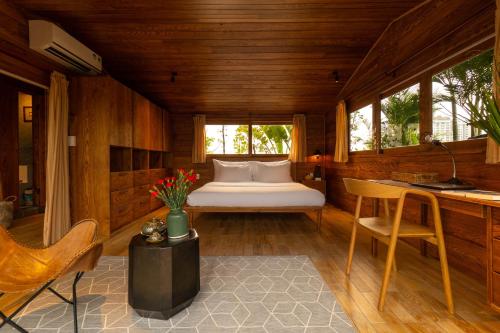 a bedroom with a bed and a table and chairs at Nexus House Lang Bao Chi in Ho Chi Minh City