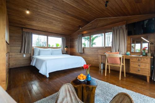 a bedroom with a bed and a desk with a table at Nexus House Lang Bao Chi in Ho Chi Minh City