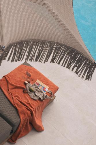 a tshirt sitting on a bed with a towel at La Brise Luxury Suites in Néa Péramos
