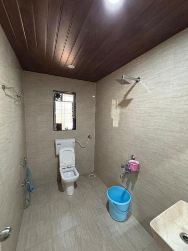 a bathroom with a toilet and a blue bucket at Saanjh in Pali