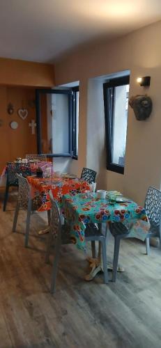 a dining room with a table and chairs with flowers on it at Hôtel Saint Florent in Orange