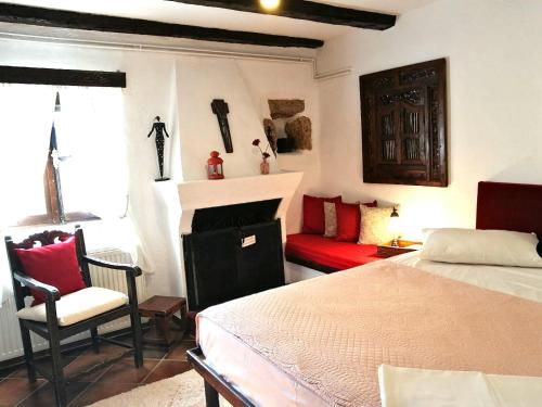 a bedroom with a bed and a red couch at Ampelos Estate in Akrata