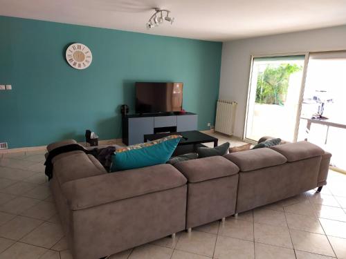 - un canapé brun dans un salon aux murs bleus dans l'établissement Superbe VILLA avec piscine, à Six-Fours-les-Plages