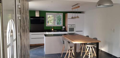 une cuisine avec des armoires blanches et une table en bois dans l'établissement Superbe VILLA avec piscine, à Six-Fours-les-Plages