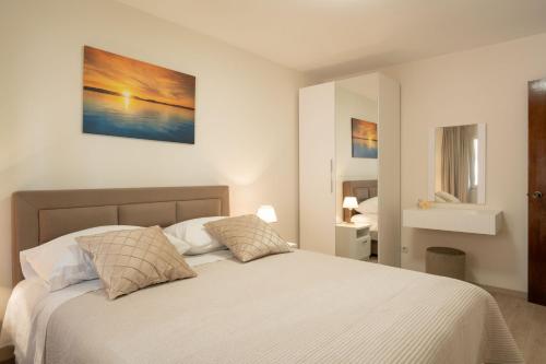 a bedroom with a white bed with two pillows at Apartments Linda in Prizba