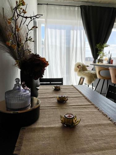 a dining room table with a vase and plates on it at Cozy loft-duplex penthouse in Il-Gżira