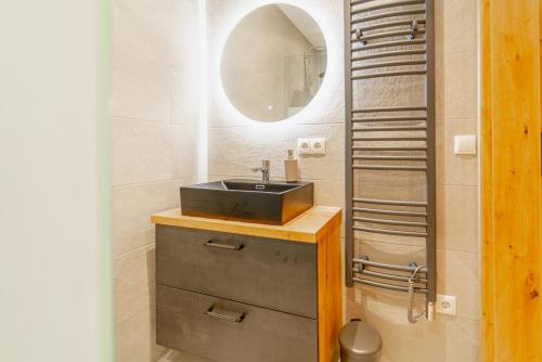 a bathroom with a sink and a mirror at Oetztaler Lausbubenhaus Max & Moritz in Ötztal-Bahnhof