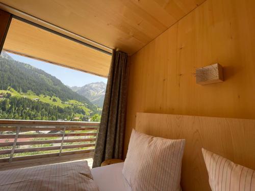 a bedroom with a window with a view of a mountain at Walserkreuz Suiten in Hirschegg