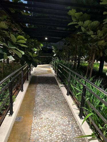 a walkway in a garden with trees and plants at KL Central 32 Floor KLCC View in Kuala Lumpur