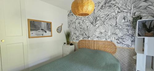 ein Raum mit einem Stuhl und einer Wand mit einer Tapete in der Unterkunft Pause Luzienne à deux pas de la plage in Saint-Jean-de-Luz