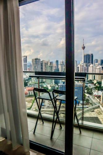 a balcony with a table and a view of a city at KL Central 32 Floor KLCC View in Kuala Lumpur