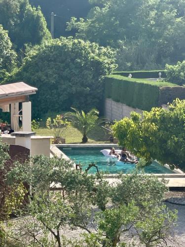 un groupe de personnes dans une piscine dans l'établissement Belle bastide provençale, à Noves