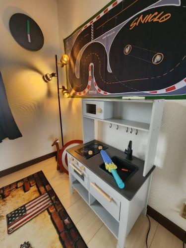 a room with a table with a race track mural on the wall at 【芦ノ湖徒歩10分＆バス停1分】一棟貸切最大14人 大人數BBQ可能 パーティ 『ROUTE99』 in Moto-hakone