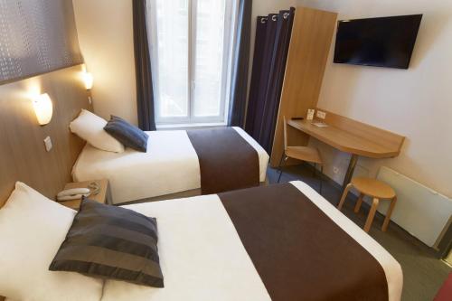 a hotel room with two beds and a desk at Hotel Paris Villette in Paris