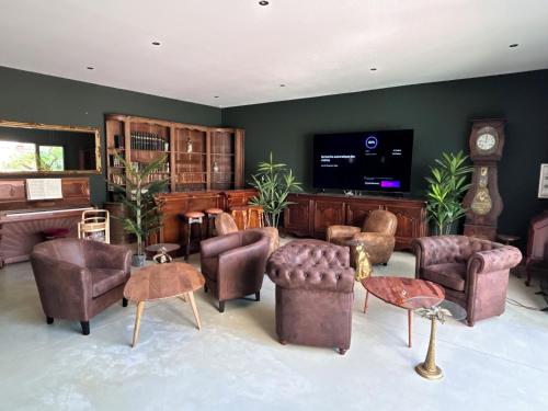 a living room filled with furniture and a flat screen tv at La Maison Coloniale Suites privatives de luxe in Torreilles
