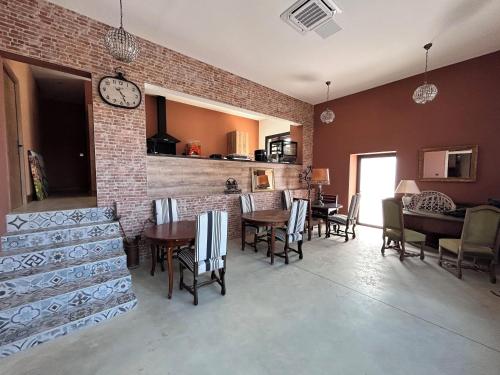 a dining room with chairs and a clock on the wall at La Maison Coloniale Suites privatives de luxe in Torreilles