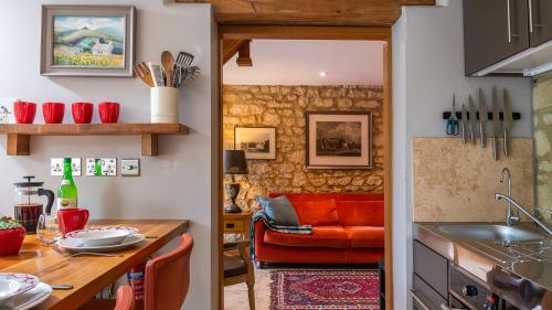 a kitchen and living room with a red couch at Little Coach House in Beckley