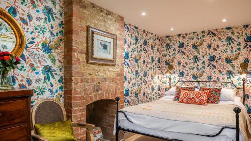 a bedroom with a bed in a room with floral wallpaper at Little Coach House in Beckley